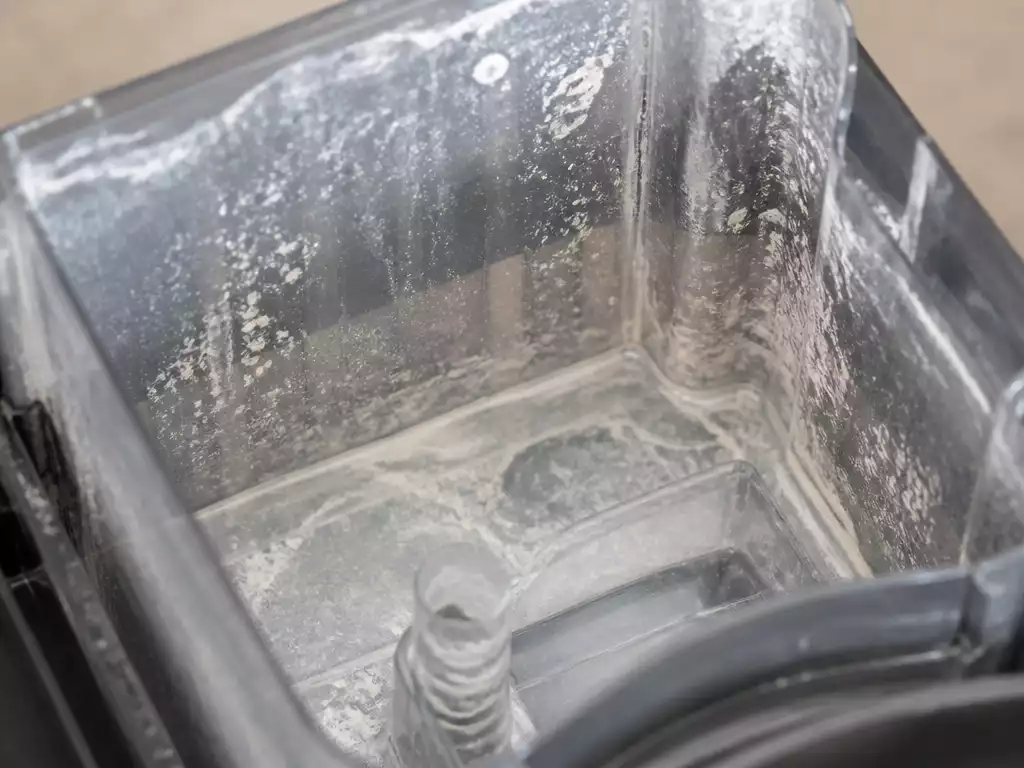 Close-up of mineral buildup inside a coffee maker's water reservoir