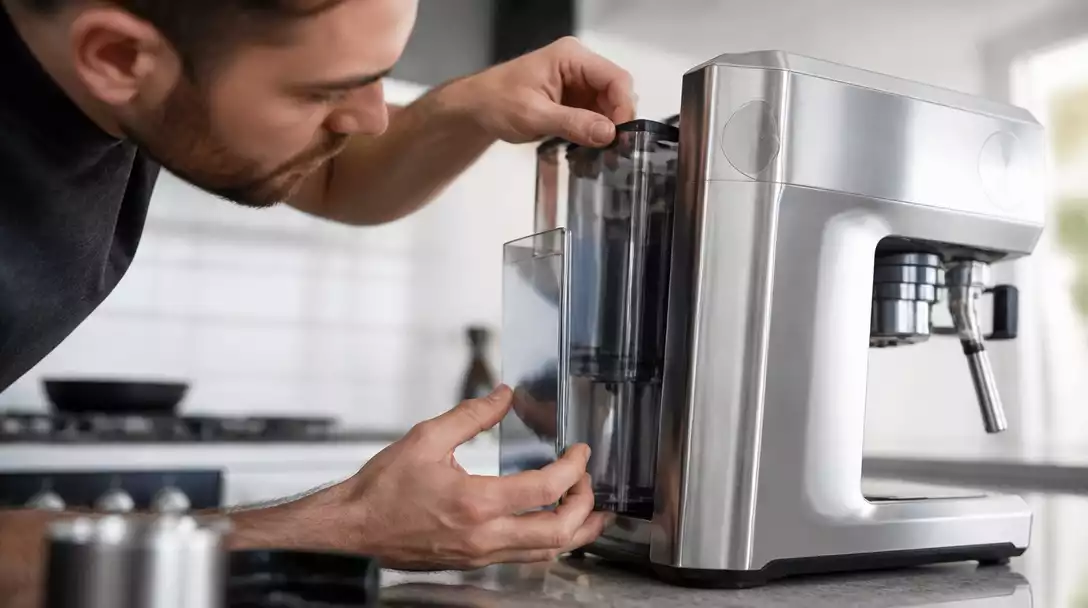 Person inspecting a Breville coffee maker for low water flow, checking the reservoir and pipes