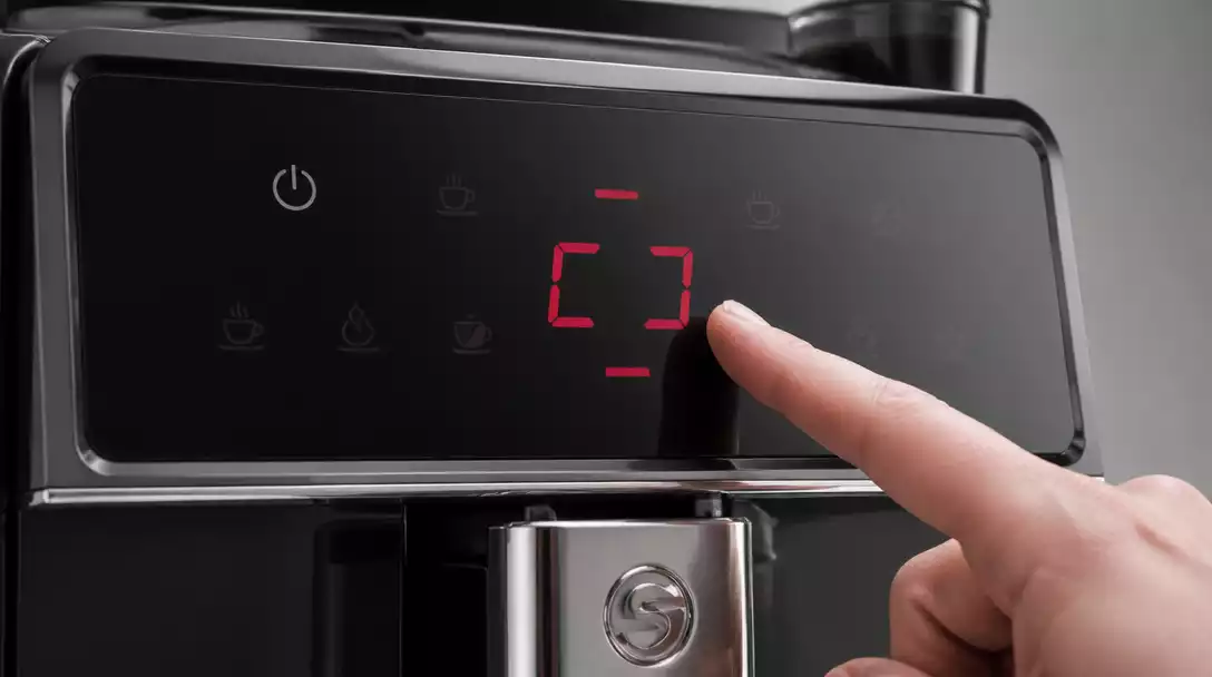 Close-up of a Saeco coffee maker's control panel displaying an error code with a hand pointing to it